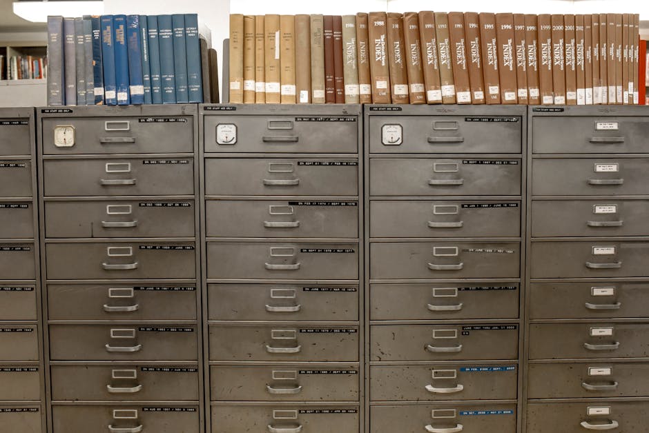 Organized filing cabinets stacked with indexed books in a library setting.